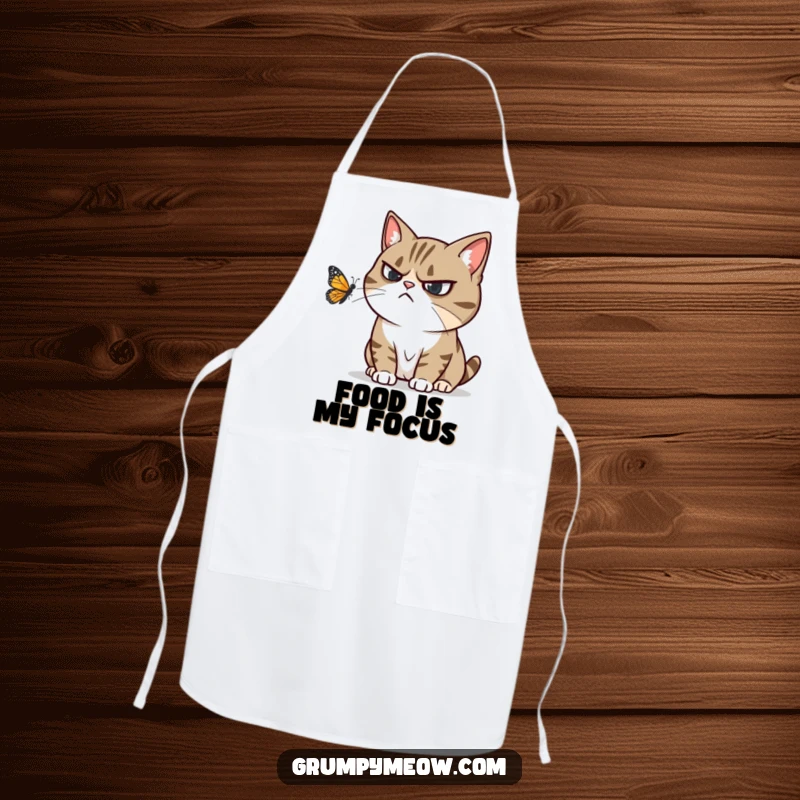 Funny apron with a grumpy cat trying to ignore a playful butterfly, expressing humorous annoyance in the kitchen.