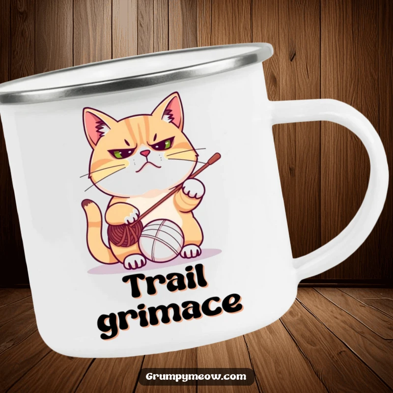 Funny camping mug with a grumpy cat frowning while playfully swatting at a yarn ball, ideal for outdoor adventures and cozy moments.