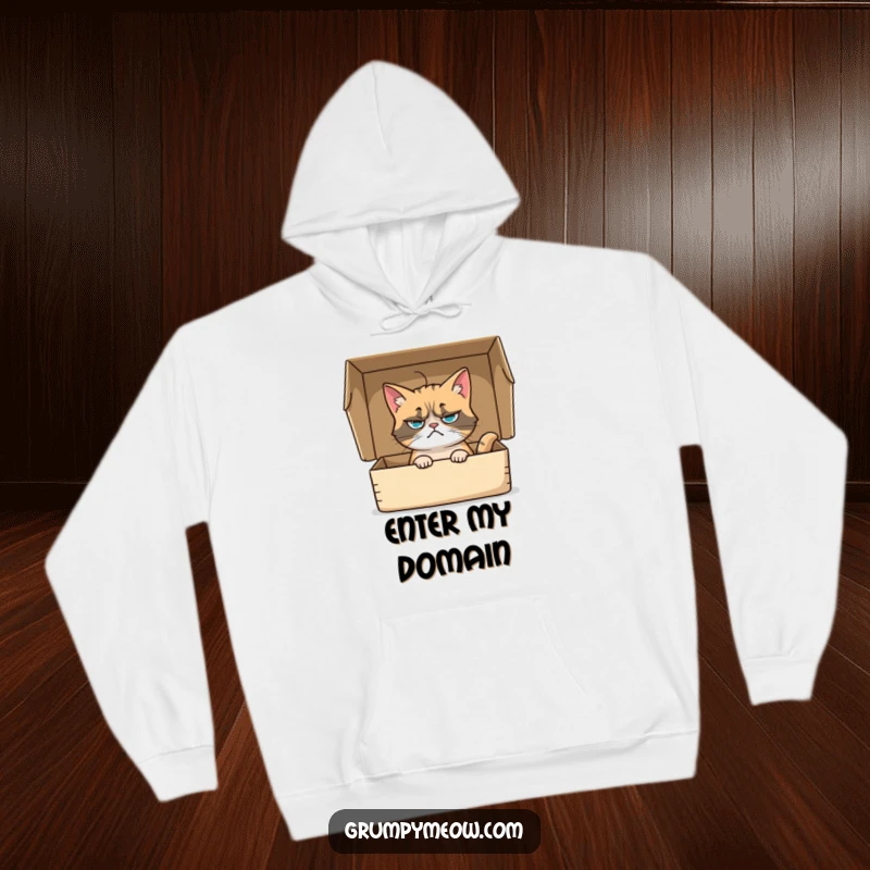 Funny hoodie showcasing a grumpy cat nestled in a box, its whisker twitching with subtle curiosity, an amusing gift for cat lovers.