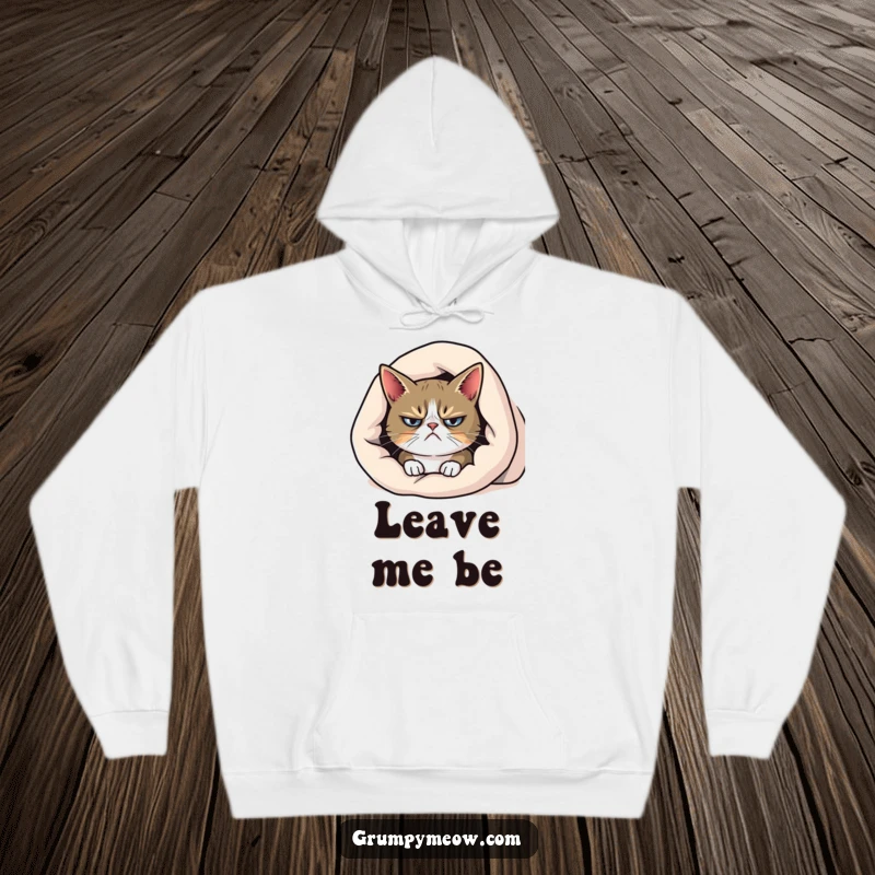 Funny grumpy cat hoodie, peeking from beneath a blanket with a frown, offering warmth and relatable morning moods.