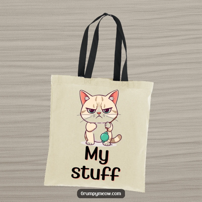 Funny Tote Bag with a grumpy cat looking unimpressed while swatting a dangling toy, perfect for carrying essentials with feline apathy.